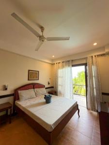 a bedroom with a bed with a ceiling fan at Hotel Grand Luis in Dauis