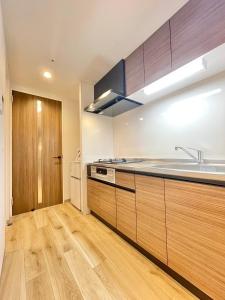 a kitchen with wooden cabinets and a sink at TIC HOTEL Hisayaodorisakae in Nagoya +20 photos