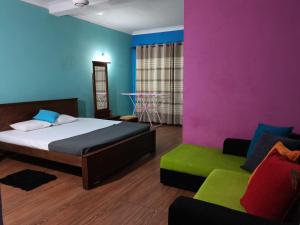 a bedroom with a bed and a couch at Ceylon Traveller Homestay for Foreign Tourists in Panadura