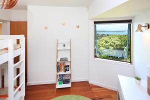 a bedroom with a window and a book shelf at The Lookout in Oneroa