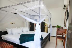 a bedroom with a bed with a canopy at Yala Elegant Hotel in Tissamaharama