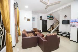 a living room with couches and a flat screen tv at Yala Elegant Hotel in Tissamaharama