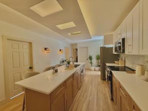 a large kitchen with white counter tops and cabinets at Spring Rooms by Yale & Downtown in New Haven