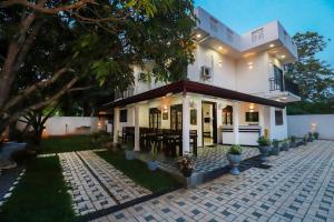 a white house with a patio in front of it at Yala Elegant Hotel in Tissamaharama