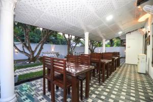 a row of wooden tables and chairs on a patio at Yala Elegant Hotel in Tissamaharama