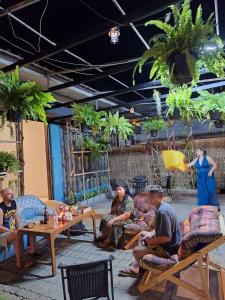 a group of people sitting at tables in a patio at 99Hostel&Bar Koh Chang in Ko Chang