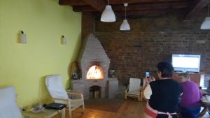 a woman taking a picture of a fireplace in a living room at Pensiunea Leia in Cârțișoara