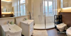 a bathroom with two sinks and a shower and a toilet at Hostel Alfar in Sarajevo