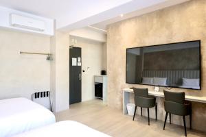 a hotel room with a large tv on the wall at 芙蘿拉萃旅 in Taitung City