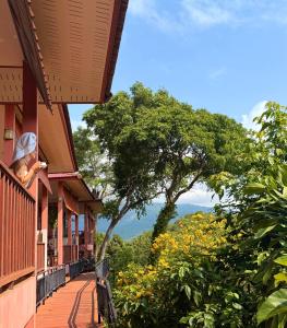 a woman standing on a balcony looking out at the mountains at PawPaw Resort in Lamai