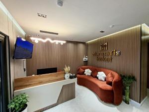a living room with a couch and a television at Marmaris Rakat Hotel in Yakkasaray