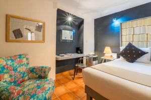 a bedroom with a bed, a desk, and a lamp at Hotel Damiana Boutique in Querétaro