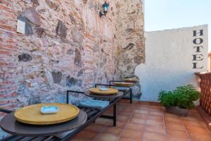 2 mesas en una habitación con una pared de ladrillo en Hotel Damiana Boutique en Querétaro