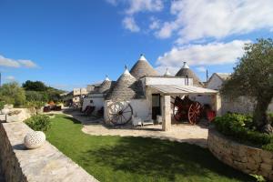 a house with a mill with a grass yard at Il Gabellota Resort in Alberobello