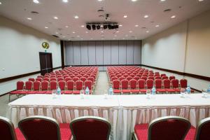 a conference room with red chairs and tables and a podium at Grand Palladium Imbassaí Resort & Spa - All Inclusive in Imbassai