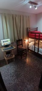 a bedroom with a bed and a desk with a computer at Departamento PyA in San Miguel de Tucumán