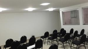 an empty room with black chairs and a window at Mardan Hotel in Parauapebas