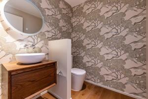 a bathroom with a toilet and a mirror at Perfection on Park Lane in Timaru +20 photos