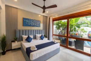 a bedroom with a bed and a large window at I Ahangama - 100m to Kabalana Beach in Ahangama