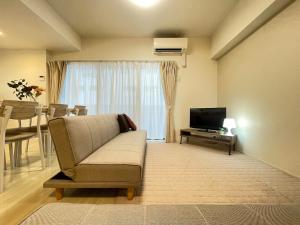 a living room with a couch and a television at TIC HOTEL Marunouchisakae in Nagoya