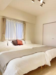 two beds in a bedroom with a window at TIC HOTEL Marunouchisakae in Nagoya
