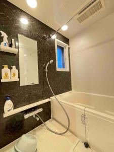 a bathroom with a shower and a sink and a tub at TIC HOTEL Marunouchisakae in Nagoya +11 photos