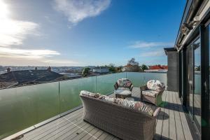 a balcony with two chairs and a table at Perfection on Park Lane in Timaru