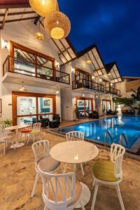 a pool with tables and chairs next to a building at I Ahangama - 100m to Kabalana Beach in Ahangama
