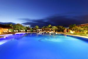 a large blue swimming pool at night at Grand Palladium Imbassaí Resort & Spa - All Inclusive in Imbassai