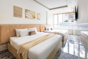 a hotel room with two beds and a couch at Nghia Lan Hotel - Dalat Market in Da Lat +89 photos