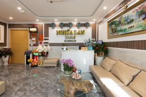 a lobby of a hotel with a couch and flowers at Nghia Lan Hotel - Dalat Market in Da Lat