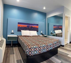 a bedroom with a large bed with a blue wall at La Casa Motel, Los Angeles - Burbank Airport in Sun Valley