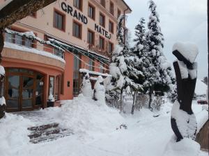 a building with a pile of snow in front of it at Hotel & Penzión Grand Matej in Banská Štiavnica