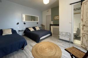 a bedroom with two beds and a table at Aux Chambres des Dames in Chisseaux