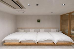 a bedroom with a large bed with white sheets at Relax Hotel Takayama Station in Takayama +47 photos