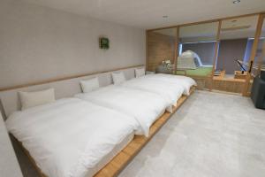 two beds in a room with white sheets at Relax Hotel Takayama Station in Takayama