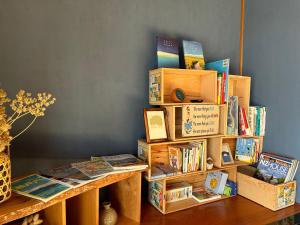 a book shelf filled with books next to a table at Kia Ora Setouchi in Shodoshima