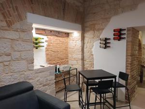 a dining room with a table and chairs and a stone wall at Il rifugio del tempo - Domus Marconi in Campobasso