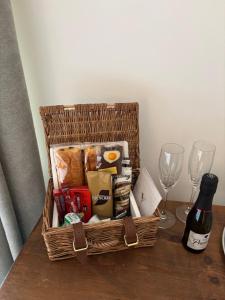a basket with food and a bottle of wine on a table at Boutique Rooms at The Ellesmere in Hornsea