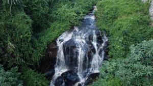 an aerial view of a waterfall in a forest at Kitusuru staycation in Wabuga