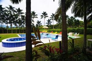 a swimming pool with palm trees in a resort at Alojamiento rural el Refugio en santagueda in Santagueda