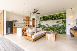 an open living room with a couch and a kitchen at Yemaya Villas in Kuta Lombok