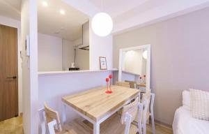 a kitchen and dining room with a wooden table and chairs at TIC HOTEL NAGOYA Station in Nagoya