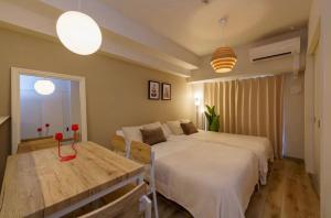 a bedroom with a bed and a table in it at TIC HOTEL NAGOYA Station in Nagoya