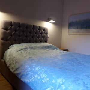 sypialnia z łóżkiem z niebieską kołdrą w obiekcie Poles Apart w mieście Ax-les-Thermes