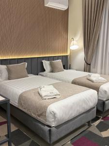 a hotel room with two beds with towels on them at Marmaris Rakat Hotel in Yakkasaray