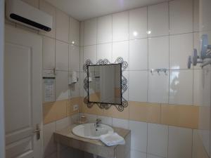 a bathroom with a sink and a mirror at Logis hôtel restaurant Le clos saint loup in Bram +21 photos