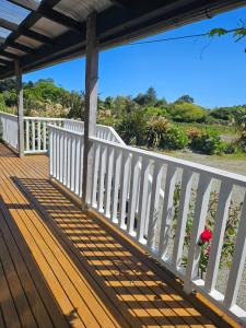 a porch with a white fence and a bench at The Blackhouse Cottage in Hokitika +25 photos