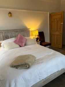 a bedroom with a large white bed with two pillows at Boutique Rooms at The Ellesmere in Hornsea