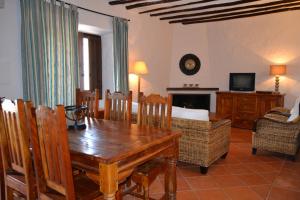 a living room with a wooden table and chairs at Cortijo de Bornos in Cambil